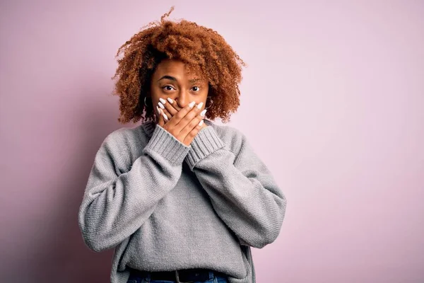 カジュアルなセーターを着て巻き毛を持つ若い美しいアフリカ系アメリカ人アフロ女性は間違いのために手で口をカバーショックを受けた 秘密概念 — ストック写真