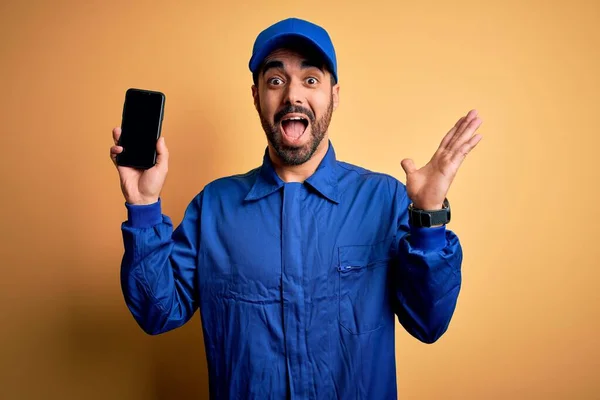 Mechanic Man Beard Wearing Blue Uniform Cap Holding Smartphone Showing — Stock Photo, Image