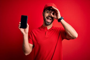 Sakallı, akıllı telefonlu yakışıklı teslimatçı gülümseyen yüzüyle yemek uygulaması sunuyor.