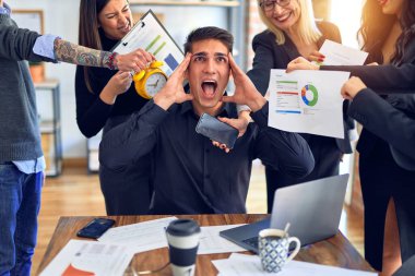 Group of business workers working together. Partners stressing one of them at the office