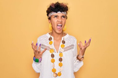 Genç ve güzel Afro-Amerikan Afro-Amerikan kadın güneş gözlüğü ve aksesuar takıyor. Deli gibi bağırıyor ve agresif bir ifade ve kolla bağırıyor. Hayal kırıklığı konsepti.