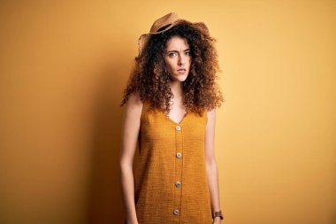 Güzel esmer kadın tatilde. Kıvırcık saçlı ve piercing takıyor. Kuşkucu ve gergin. Negatif kişi.
