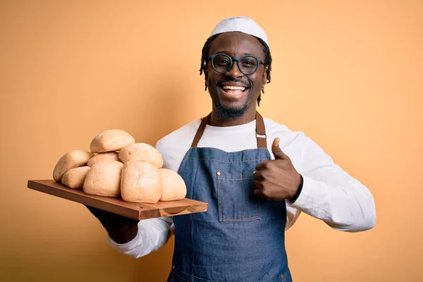 Joven Afroamericano Panadero Hombre Usando Delantal Celebración Bandeja Con Pan —  Fotos de Stock