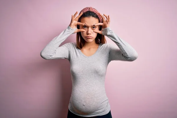 若いです美しいですティーン女の子予想赤ちゃん以上に隔離されたピンクの背景指で目を開こうとしています 眠いと疲れています朝の疲労 — ストック写真