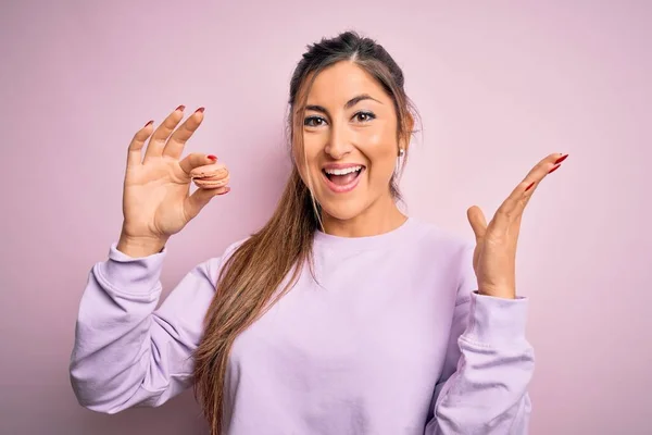 Joven Hermosa Mujer Comiendo Pastelería Francesa Dulce Macaron Sobre Rosa — Foto de Stock