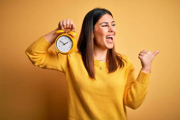 Jeune Belle Femme Tenant Réveil Debout Sur Fond Jaune Isolé — Photo