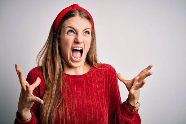 赤いカジュアルなセーターを着た若い美しい赤毛の女性は 黄色の背景に狂気と怒りの叫びと積極的な表現と腕を上げて叫んでいます 欲求不満の概念 — ストック写真