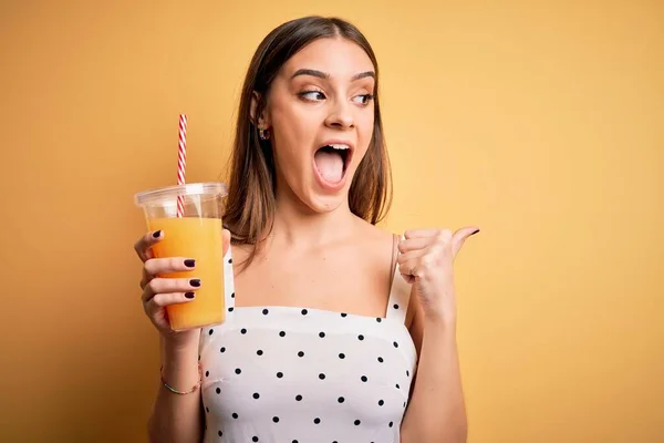 Jong Mooi Brunette Vrouw Drinken Gezond Sinaasappelsap Gele Achtergrond Wijzend — Stockfoto