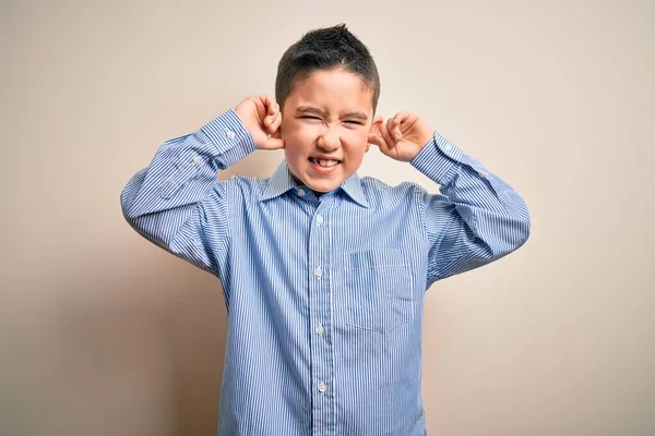 小男孩穿着雅致的衬衫 站在与世隔绝的背景音乐上 用手指捂住耳朵 对嘈杂的音乐感到恼怒 聋人概念 — 图库照片