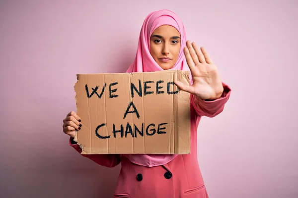 ピンクのイスラム教徒のヒジャーブを身に着けている活動家の女性バナーを保持します — ストック写真