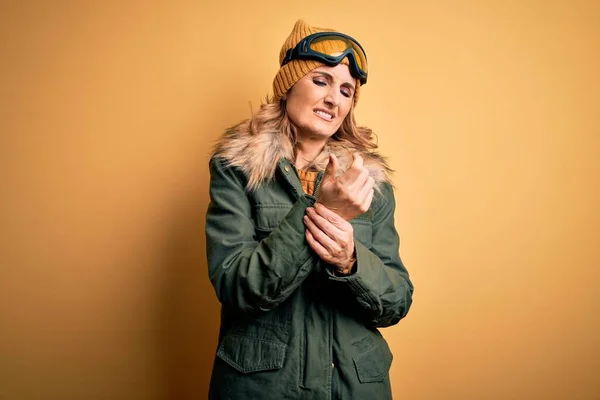 中年漂亮的金发滑雪者女人穿着雪地运动鞋和滑雪护目镜 手指头疼痛 关节炎发炎 — 图库照片