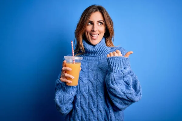 Young Beautiful Brunette Woman Drinking Healthy Orange Juice Blue Background — Stock Photo, Image