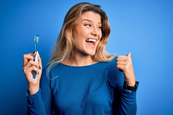 Jovem Mulher Loira Bonita Usando Escova Dentes Sobre Fundo Azul — Fotografia de Stock