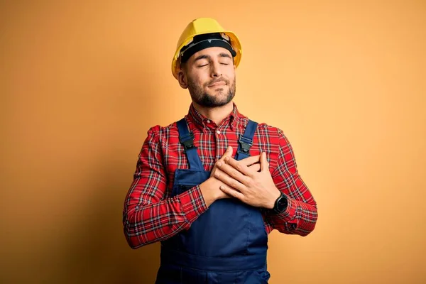 Jonge Bouwvakker Uniform Veiligheidshelm Gele Geïsoleerde Achtergrond Glimlachend Met Handen — Stockfoto