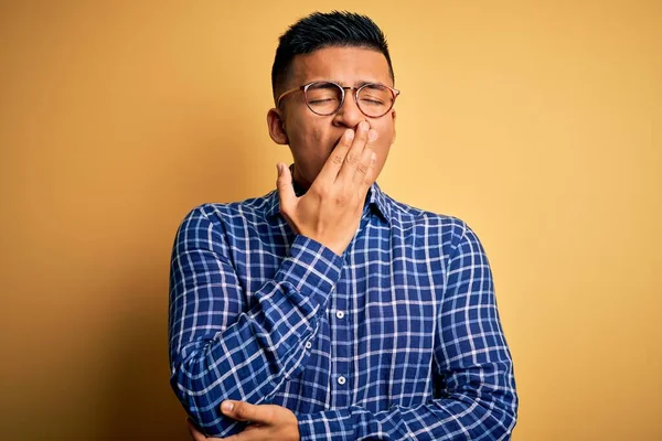 Mladý Pohledný Latinskoamerický Muž Neformální Košili Brýlích Žlutém Pozadí Znuděně — Stock fotografie