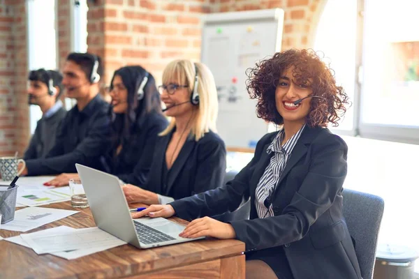 Group of call center workers smiling happy and confident. Working together with smile on face using headset at the office.