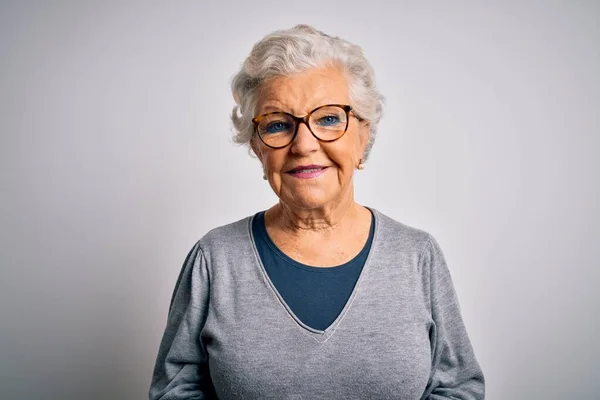 Senior beautiful grey-haired woman wearing casual sweater and glasses over white background with a happy and cool smile on face. Lucky person.