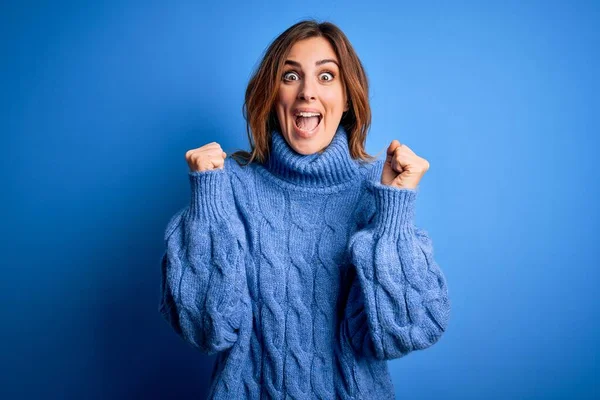 Młoda Piękna Brunetka Ubrana Luźny Sweter Niebieskim Tle Świętująca Sukces — Zdjęcie stockowe