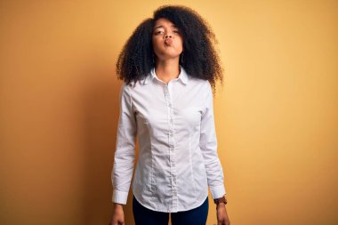 Afro saçlı, güzel, Afro-Amerikan zarif bir kadın. Arka planda duran, komik yüzlü, pofuduk yanakları olan. Havayla şişmiş ağız, çılgın bir ifade..