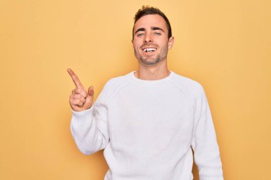 Mavi gözlü, sıradan bir süveter giyen, yüzünde kocaman bir gülümsemeyle kameraya bakan genç ve yakışıklı bir adam..