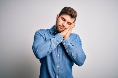 Sakallı, mavi gözlü, sıradan bir kot gömlek giyen, yorgun uyuyan, hayal kuran, elleri ve gözleri kapalı gülümseyen genç, yakışıklı sarışın bir adam..