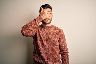 İzole edilmiş beyaz arka plan üzerinde duran, ciddi ve üzgün görünen genç, yakışıklı bir adam. Görme, saklama ve reddetme konsepti