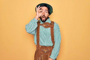 Almanya festivali için geleneksel Alman Ekim Festivali kıyafeti giyen yakışıklı genç adam şaşırmış yüz ifadesiyle şaşırmış, parmaklarından bakan bir jest yapıyor. İnançsız ifade.