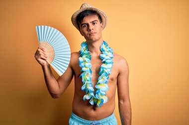 Tatilde olan genç bir turist mayo giyiyor ve Hawaii çiçekleri el ele tutuşuyor.