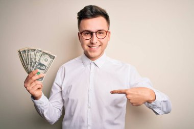 Kafkasyalı yakışıklı bir iş adamı elinde bir tomar banknotla kendini işaret ediyor.