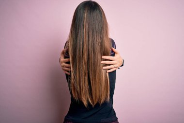 Spor kıyafetleri giyen genç sarışın kadın izole arka planda kendine mutlu ve pozitif bir şekilde sarılıyor. Sevgi ve özgüven.