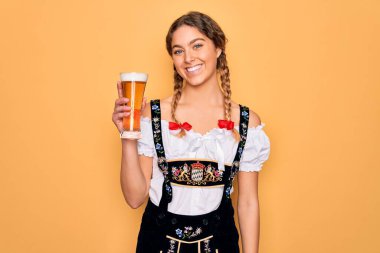 Mavi gözlü, güzel, sarışın Alman kadın. Sekizlik şenlik elbisesi giyiyor. Mutlu bir yüzle bir bardak bira içiyor.