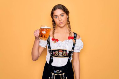 Mavi gözlü, güzel sarışın Alman kadın. Ekim festivali elbisesi giyiyor. Kendine güvenen bir ifadeyle bir kavanoz bira içiyor.