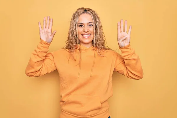 금발의 아름다운 여자가 스웨트 셔츠를 자신감 행복하게 웃으면서 손가락으로 가리키는 — 스톡 사진