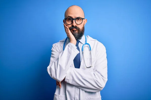 턱수염을 대머리 의사가 파란색 배경에 안경을 청진기를 피곤해 보이고 우울증 — 스톡 사진