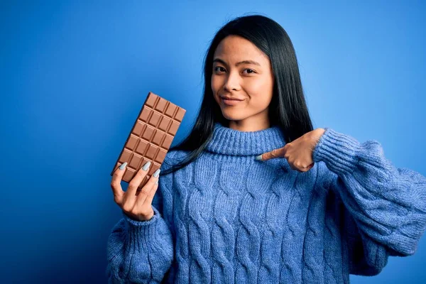 Joven Hermosa Mujer China Sosteniendo Barra Chocolate Sobre Fondo Azul —  Fotos de Stock