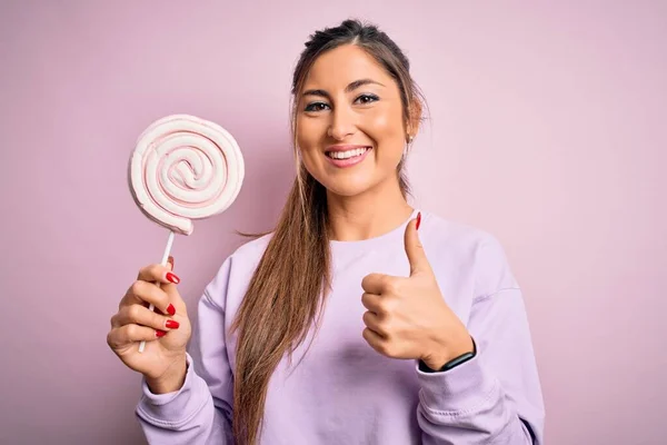 Genç Güzel Esmer Kadın Pembe Arka Planda Tatlı Şekerlemeler Yiyor — Stok fotoğraf