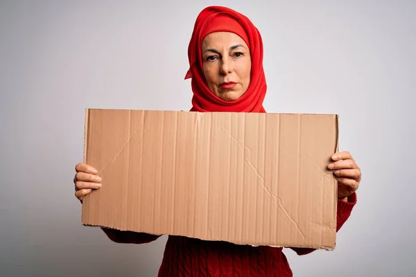 中年黑发女子 身穿传统的穆斯林头巾 高举横幅 脸上带着自信的表情 严肃地思考着 — 图库照片