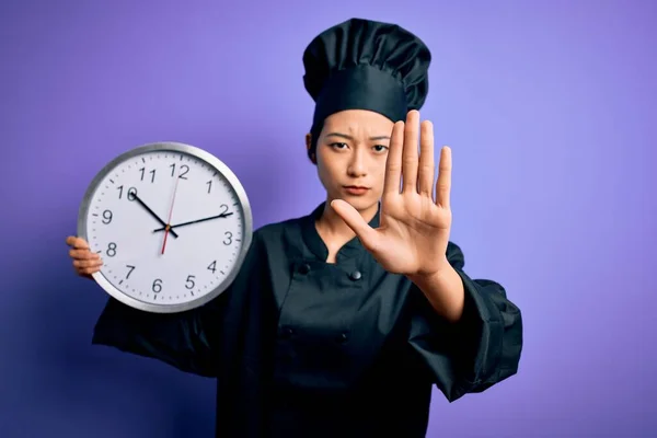 中国女厨师身穿炊具制服 头戴帽子 头戴计时器 双手张开 做手势 表情严肃自信 防守端庄 — 图库照片