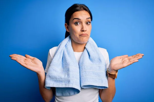 Young Beautiful Brunette Sportswoman Wearing Towel Doing Exercise Blue Background — Stock Photo, Image