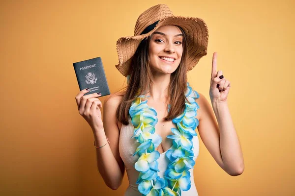 水着を着て休暇中の若い美しい観光客の女性と幸せな顔をしたアイデアや質問を指差す指で驚いてハワイレイ保持パスポート ナンバーワン — ストック写真