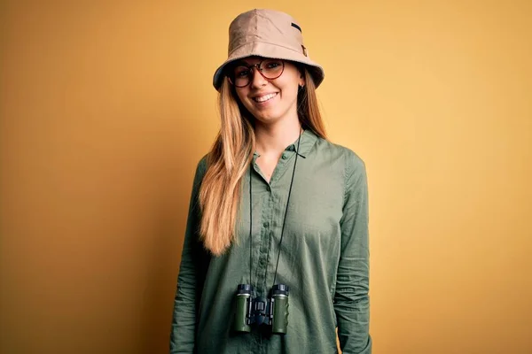 顔に幸せとクールな笑顔で双眼鏡を使用して帽子と眼鏡を着用青い目を持つ美しいブロンドの探検家の女性 運のいい人 — ストック写真