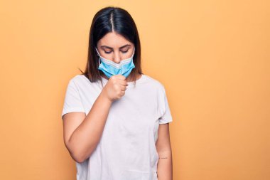 Koronavirüs hastalığı için koruyucu maske takan genç bir kadın kendini iyi hissetmiyor ve soğuk algınlığı veya bronşitin belirtisi olarak öksürüyor. Sağlık hizmeti kavramı.