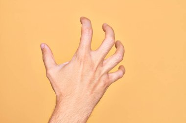 İzole edilmiş sarı arka planda parmaklarını gösteren beyaz bir gencin eli parmaklarıyla saldırganlaşmış ve şiddet ve hüsranla korkutmuştur.