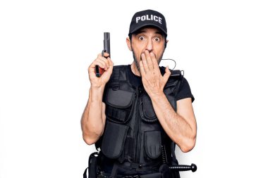 Orta yaşlı, polis üniforması giyen, kurşun geçirmez yelek giyen, ağzı silahla kaplı, şok olmuş ve hata yapmaktan korkan bir polis. Şaşırtıcı ifade.