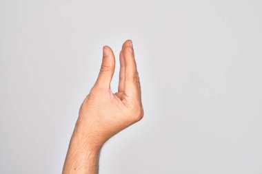 İzole edilmiş beyaz arka plan üzerinde parmaklarını gösteren beyaz bir adamın eli. Görünmez bir şeyi alıp, parmaklarıyla uzayı gösteren bir nesneyi tutuyor.