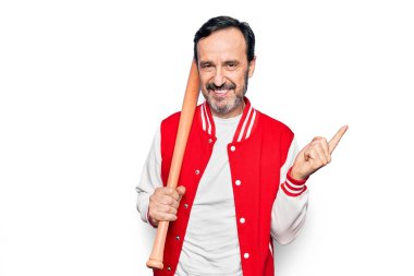 Orta yaşlı yakışıklı spor ceket giyen, beyzbol oynayan, tahta sopa kullanan, gülümseyen, eli ve parmağı yana doğru olan, mutlu bir adam.