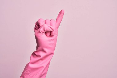 İzole edilmiş pembe arka planda temiz eldiveni olan beyaz bir gencin eli serçe parmağının söz verme sözü olduğunu gösteriyor.