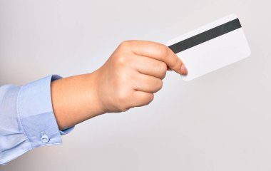 İzole edilmiş beyaz arka planda kredi kartı tutan beyaz bir kadının eli.