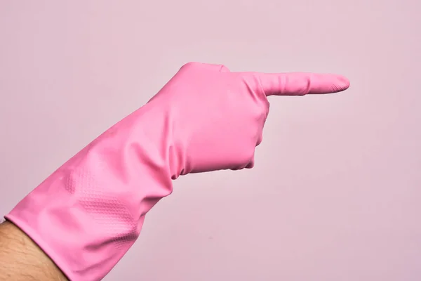 Mão Homem Jovem Caucasiano Com Luva Limpeza Sobre Fundo Rosa — Fotografia de Stock