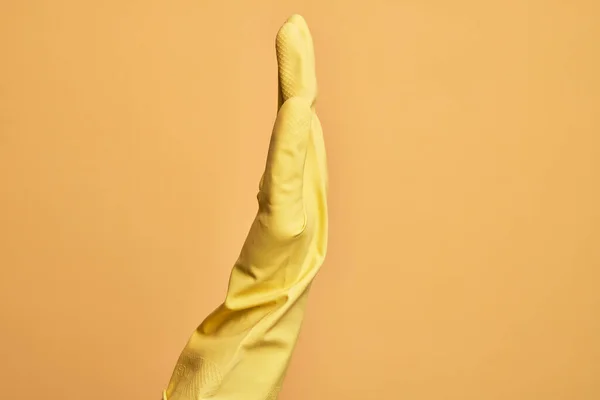 白种人的手 带着清洁手套的年轻男子的手 放在孤立的黄色背景上 显示伸出的手的侧面 推挤着 做着停止动作 — 图库照片
